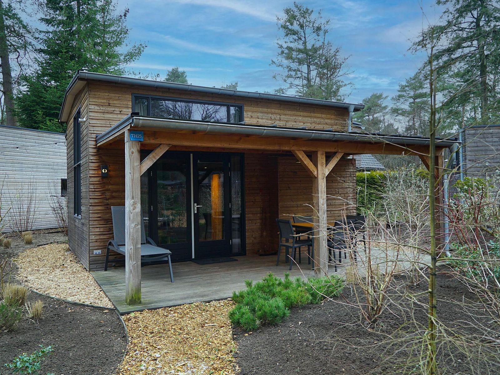 Enjoy peace and quiet on the veranda of Tiny House 4 Hottub in Beekbergen, Veluwe, surrounded by the beautiful nature of Gelderland.
