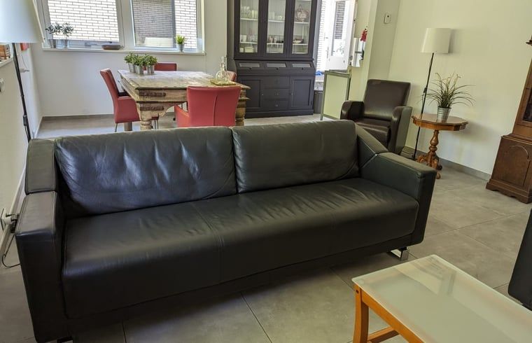 Gemuetliches Wohnzimmer des Ferienhauses in Beekbergen, Ferienhaus in der Veluwe in Gelderland, mit komfortabler Sitzecke und Essbereich.