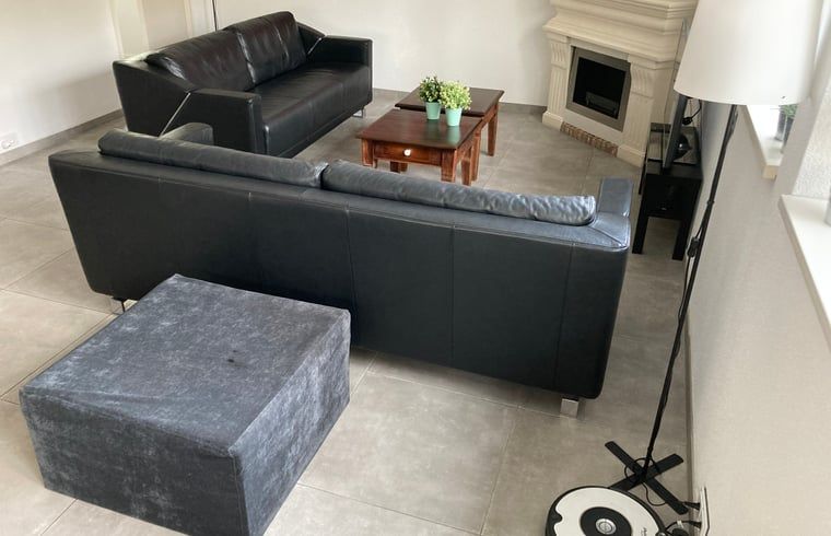 Gemuetliches Wohnzimmer des Ferienhauses in Beekbergen, Ferienhaus in der Veluwe, Gelderland, mit komfortabler Sitzecke und modernem Kamin.