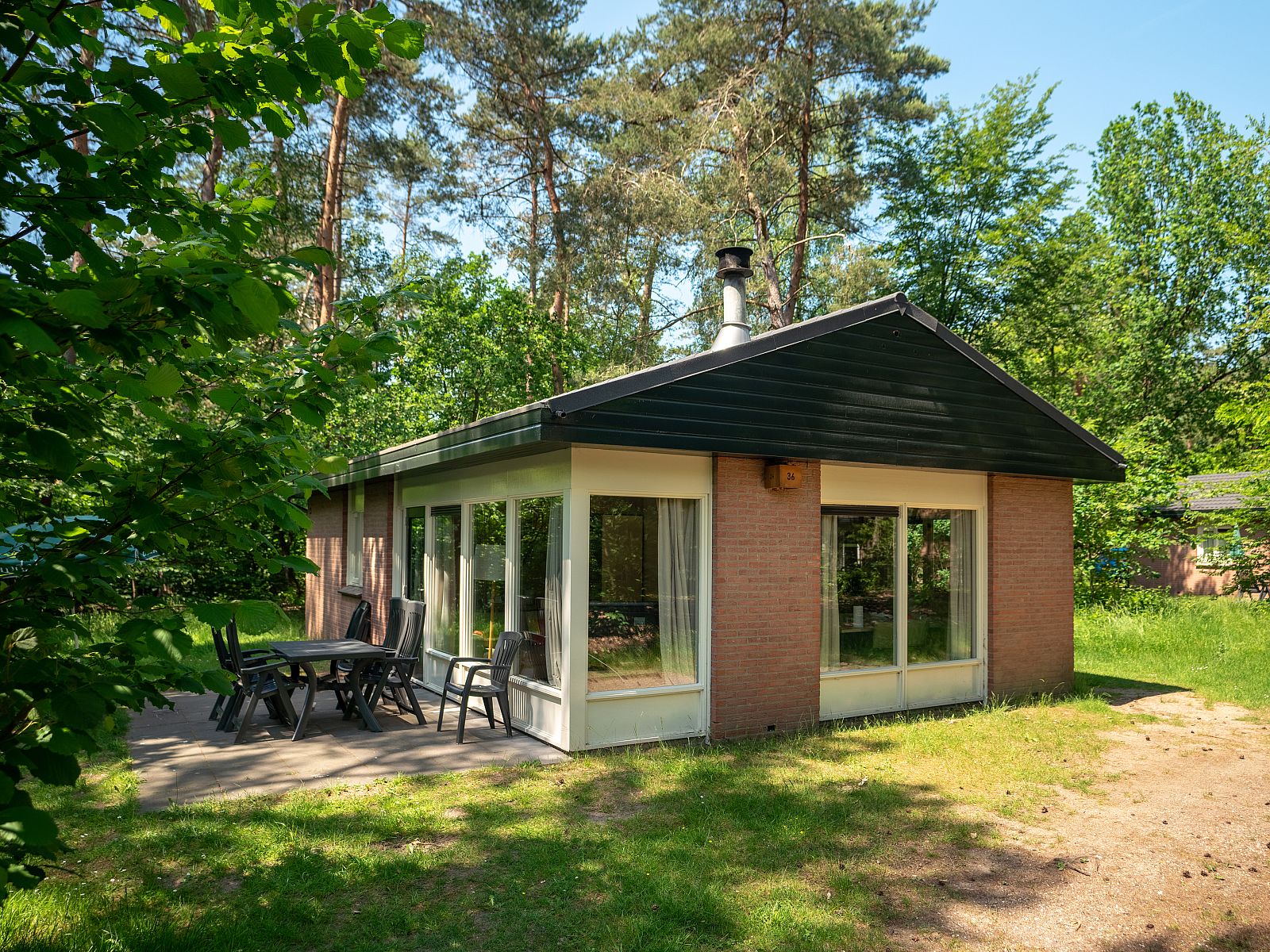 Helle Sitzecke im Ferienhaus Heideheuvel, Beekbergen, Veluwe, mit Blick auf die Natur.