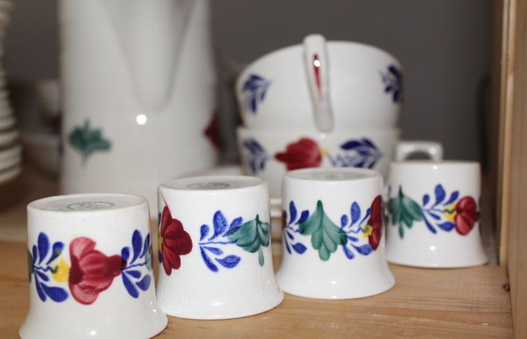 Traditioneel servies in keuken van Huisje in Kootwijk, Veluwe, voor authentieke sfeer.