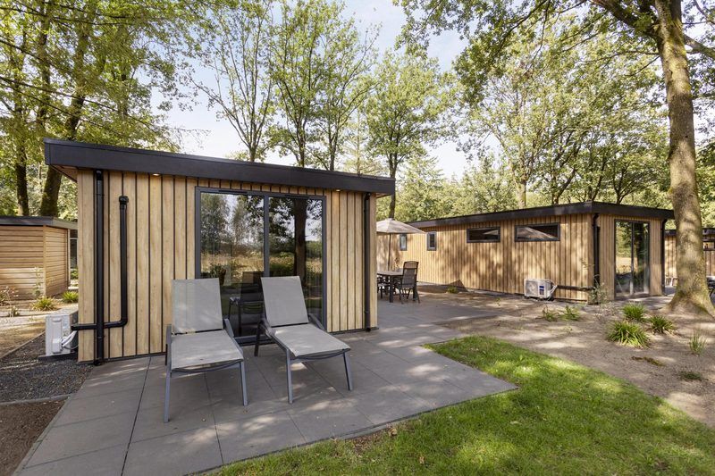 Terras van Module Wood 5 personen vakantieaccommodatie in Ede Veluwe met ligstoelen en groene omgeving.