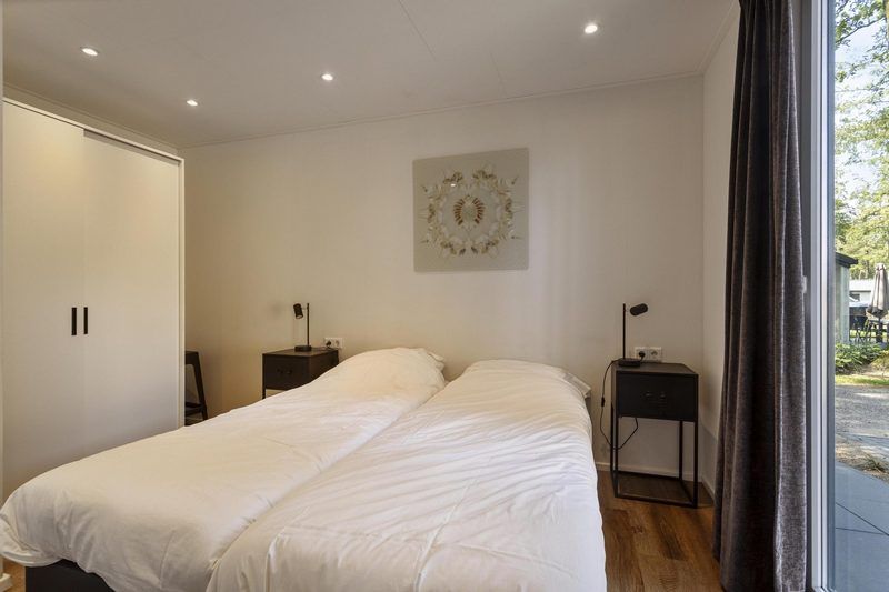 Hoofdslaapkamer van Module Wood 5 personen vakantiehuis in Ede Veluwe met tweepersoonsbed en moderne inrichting.