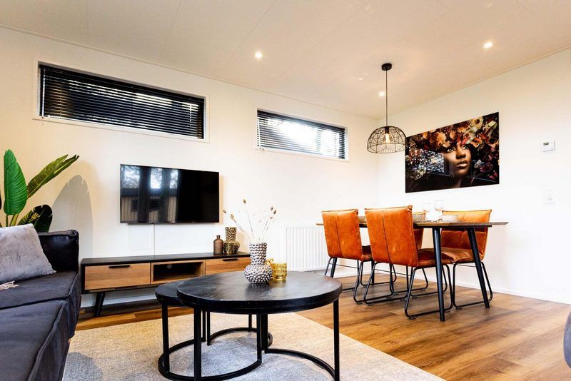 Cozy living space in Module Wood 4 persons vacation home in Ede, Veluwe with flat-screen TV and atmospheric lighting.