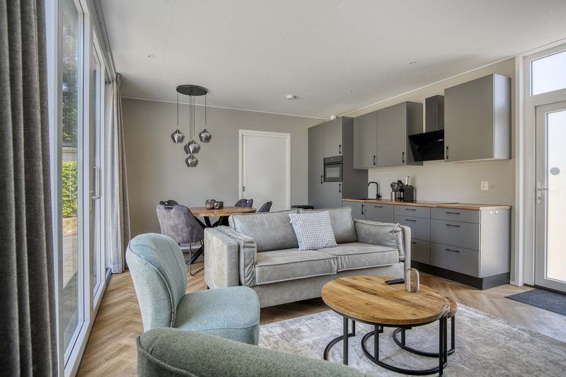 Spacious living room of Veluwehoeve 4 persons MIVA, Ede, with open kitchen and sitting area, ideal for cozy evenings on the Veluwe.