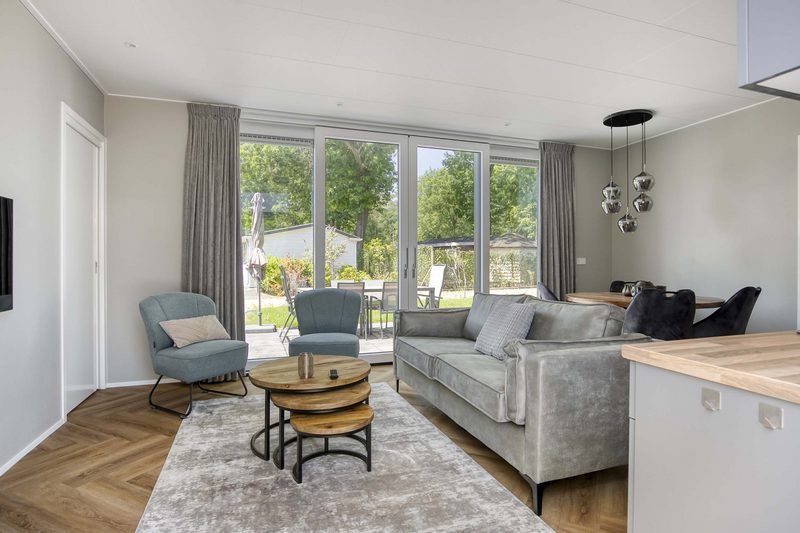 Bright living room of Veluwehoeve 4 persons MIVA in Ede, overlooking the terrace and the green surroundings of the Veluwe.