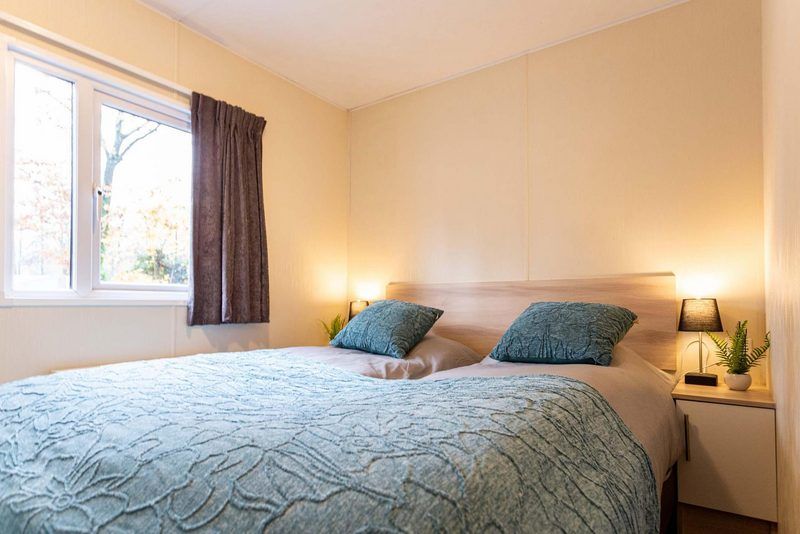 Komfortables Schlafzimmer in einem Ferienhaus fuer 6 Personen in Ede, Veluwe, Gelderland mit grossem Fenster.