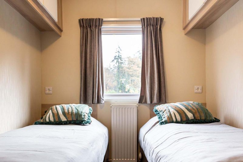Zweites Schlafzimmer im Ferienhaus in Ede, Veluwe, Gelderland mit Blick auf ein Waldgebiet.