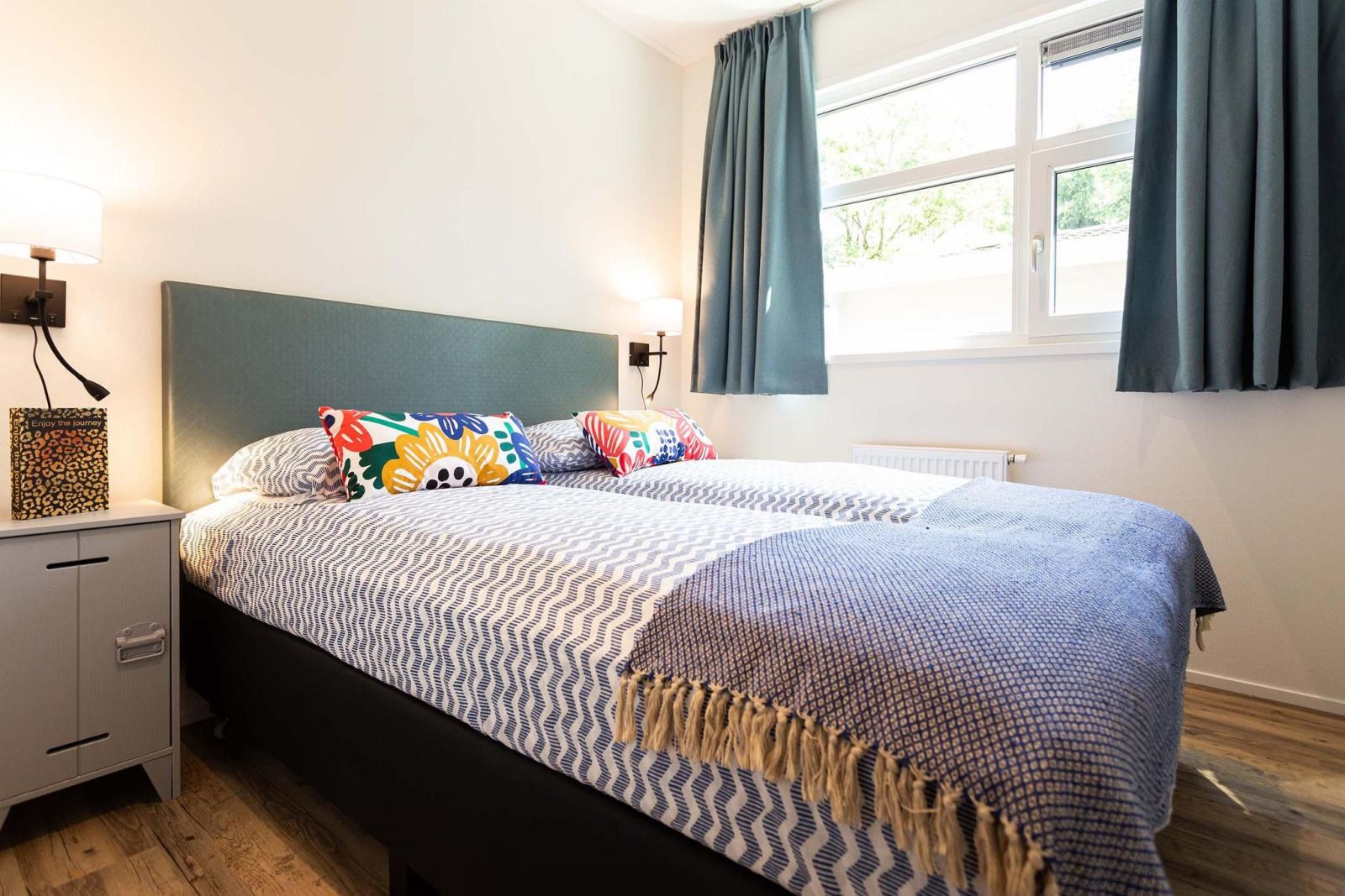 Slaapkamer in Module Special Wellness (Spa) vakantiehuis in Ede, Veluwe, Gelderland met kleurrijke kussens.