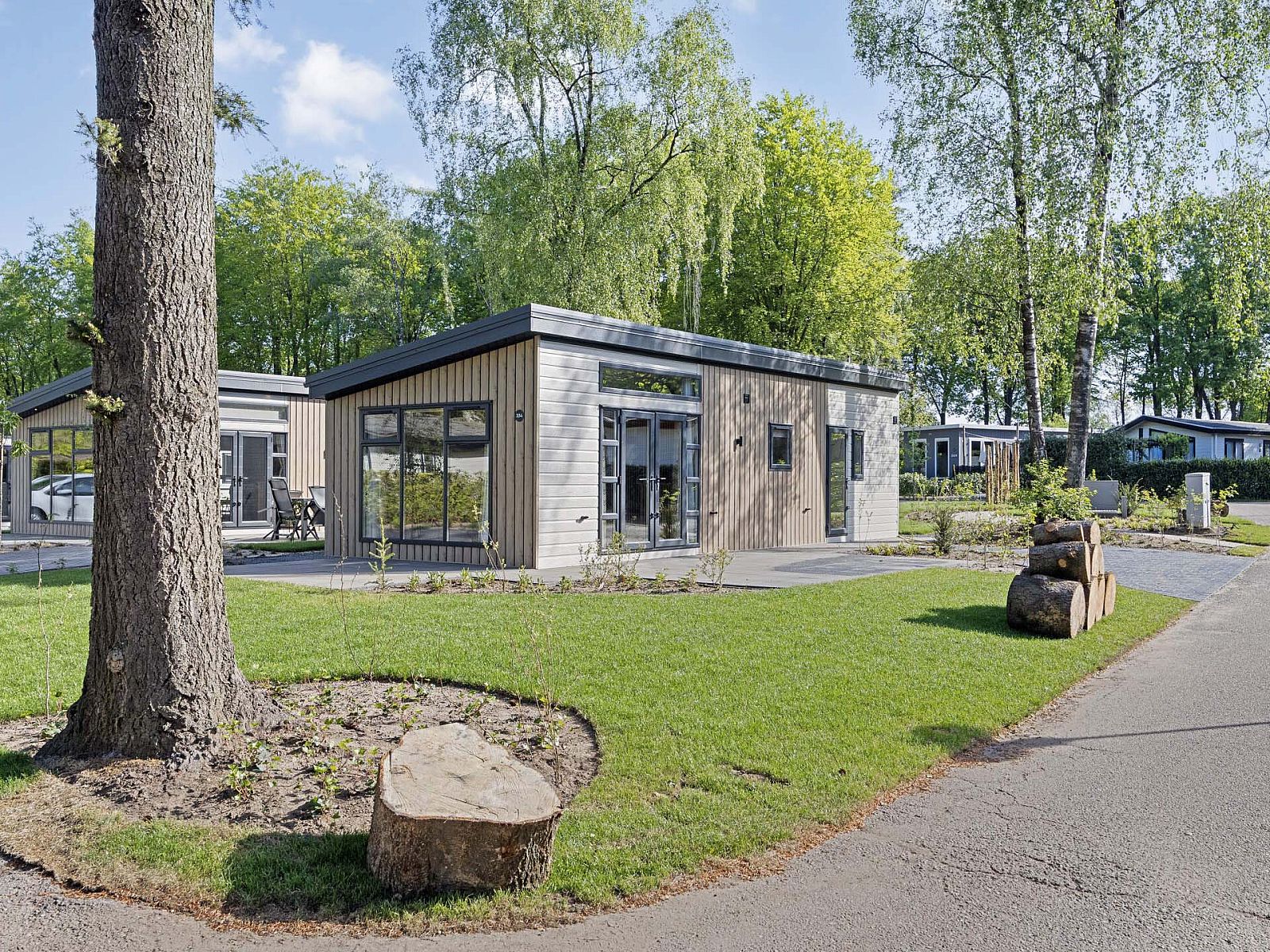 Umgebung des Ferienhauses Module Nova in Ede, Veluwe, mit Rasen und Bumen.