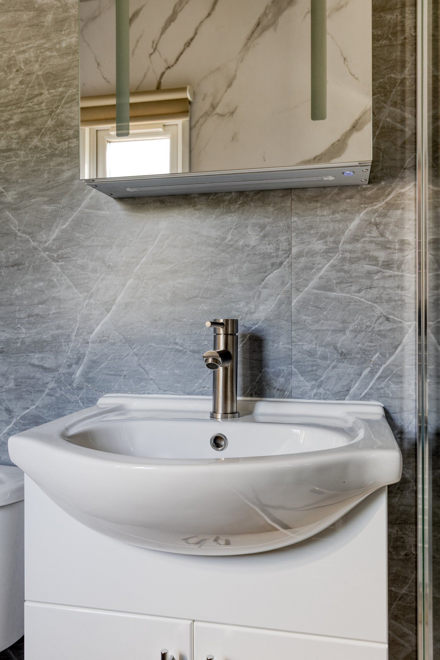 Waschbecken im Badezimmer des Ferienhauses Module Nova, Ede, Veluwe, mit Marmorwand.