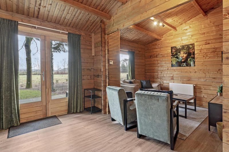 Helles Wohnzimmer in Blokhut 4 Personen, Ede, Veluwe, Gelderland, mit Blick auf die Natur.