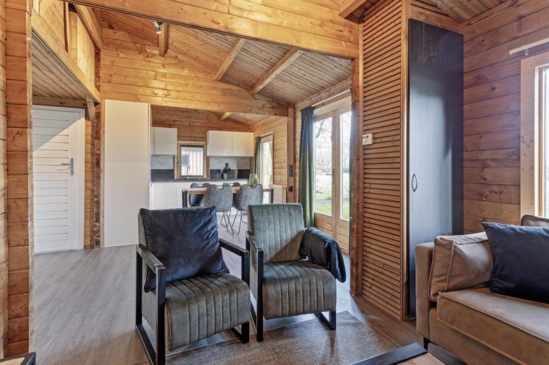 Offener Wohnbereich in Blokhut 4 Personen, Ede, Veluwe, Gelderland, mit Zugang zur Kueche und zum Wohnzimmer.