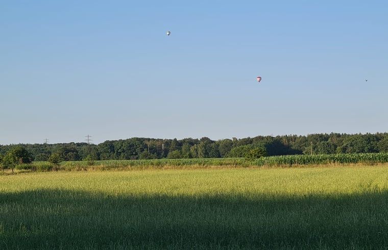 Sonnenuntergang ueber den Feldern in der Naehe des Ferienhauses in Ede, Veluwe, mit Heissluftballons.