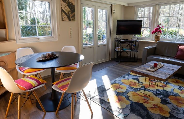 Dining area in Holiday home in Emst, Gelderland, with modern chairs and table.