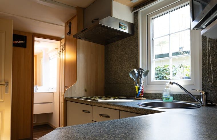 Kitchen with view in Holiday home in Emst, Veluwe, with access to the bathroom.
