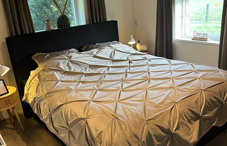 Sfeervolle slaapkamer met groot bed in Vakantiehuisje in Emst, Veluwe, Gelderland.