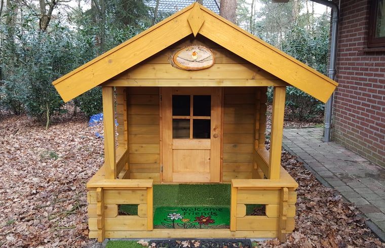 Colorful wooden playhouse next to Holiday Home in Emst, ideal for families.