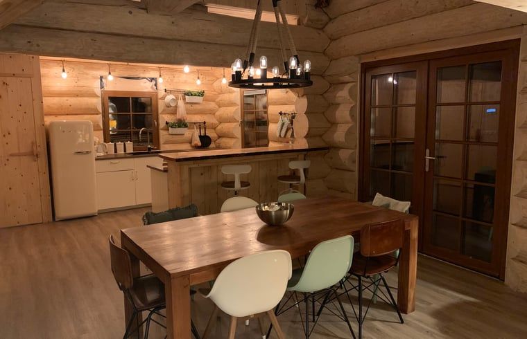 Gemuetlicher Innenbereich des Ferienhauses in Emst, Veluwe, Gelderland mit Holzinterieur und stimmungsvoller Beleuchtung.