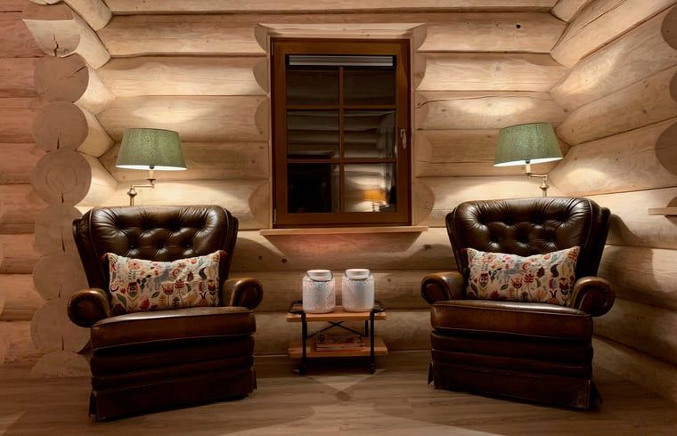 Gemuetliche Sitzecke im Ferienhaus in Emst, Veluwe. Bequeme Ledersessel und stimmungsvolle Beleuchtung in diesem gemuetlichen Ferienhaus.