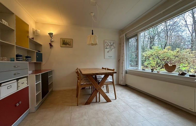 Gemuetliche Essecke im Ferienhaus in Emst, Veluwe, mit Blick auf die gruene Natur von Gelderland.