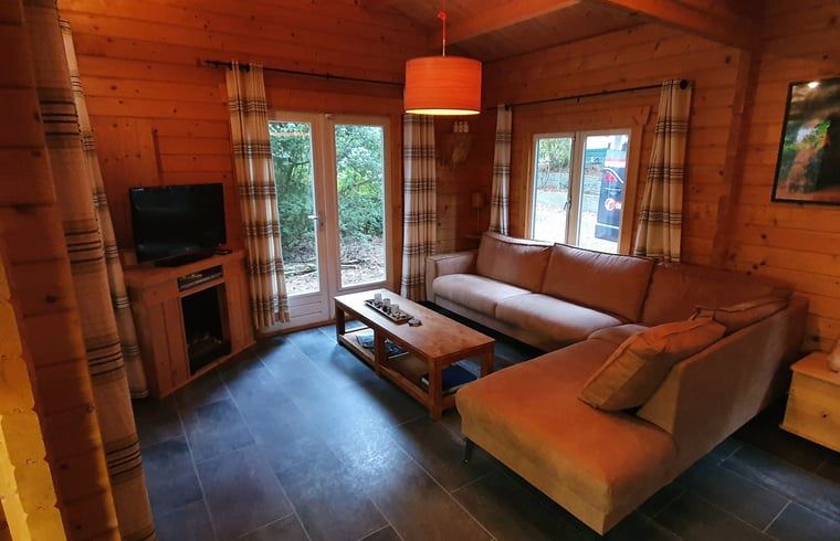 Gemuetliches Wohnzimmer des Ferienhauses in Ermelo, Veluwe, mit Blick auf die Natur.