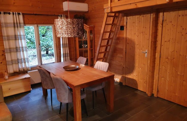 Essecke im Ferienhaus in Ermelo, Veluwe, mit Holzinterieur und moderner Beleuchtung.