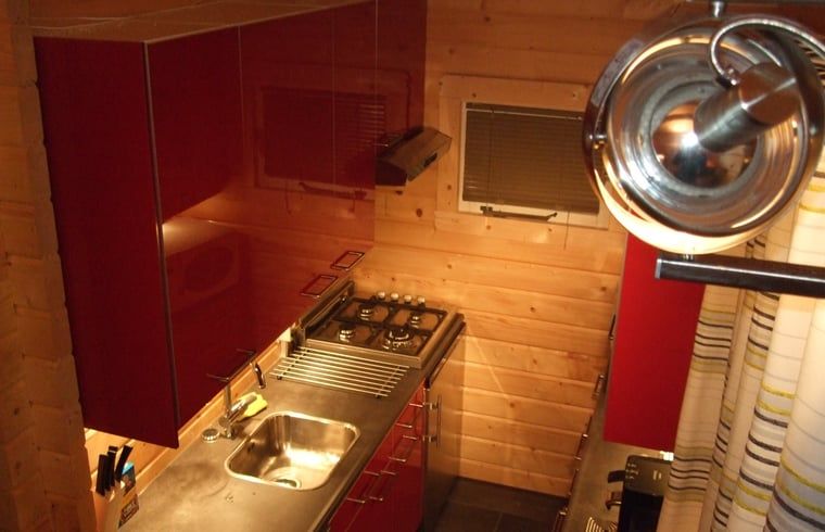 Moderne Kueche mit roten Schraenken in einem Ferienhaus in Ermelo, Veluwe.