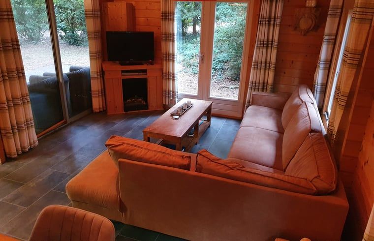 Gemuetliche Sitzecke mit TV im Ferienhaus in Ermelo, Veluwe, mit Blick auf den Garten.