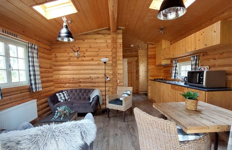 Gemuetlicher Innenbereich des Huisje in Ermelo, Ferienhaus an der Veluwe in Gelderland, mit Holzinterieur und komfortabler Sitzecke.