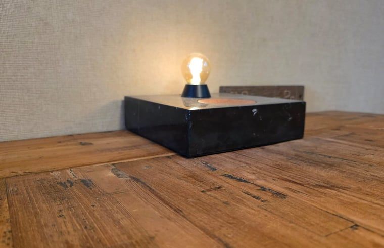 Stijlvolle tafellamp in Vakantiehuis in Hoenderloo, Veluwe, Gelderland. Gezellige binnenruimte met houten tafel voor een ontspannen verblijf.