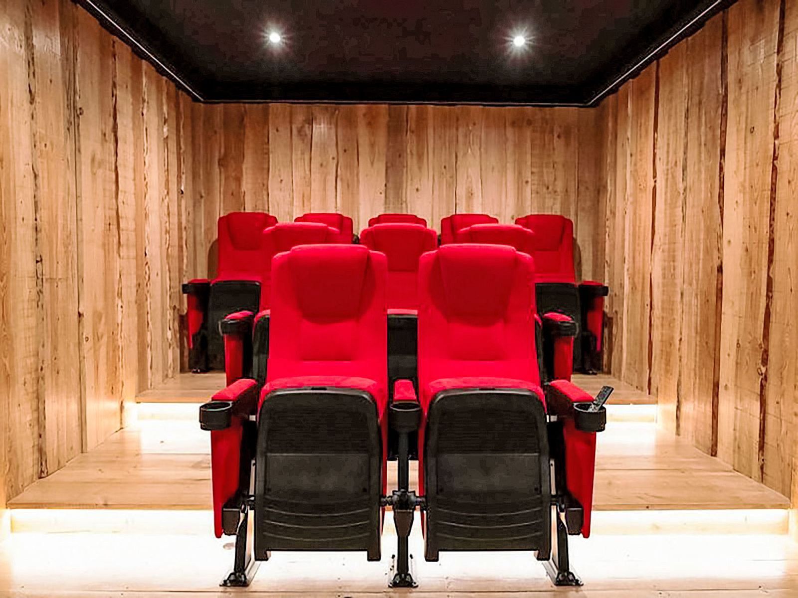 Privates Kino im Ferienhaus Specht, Hoenderloo, Veluwe, Gelderland mit roten Sitzen.