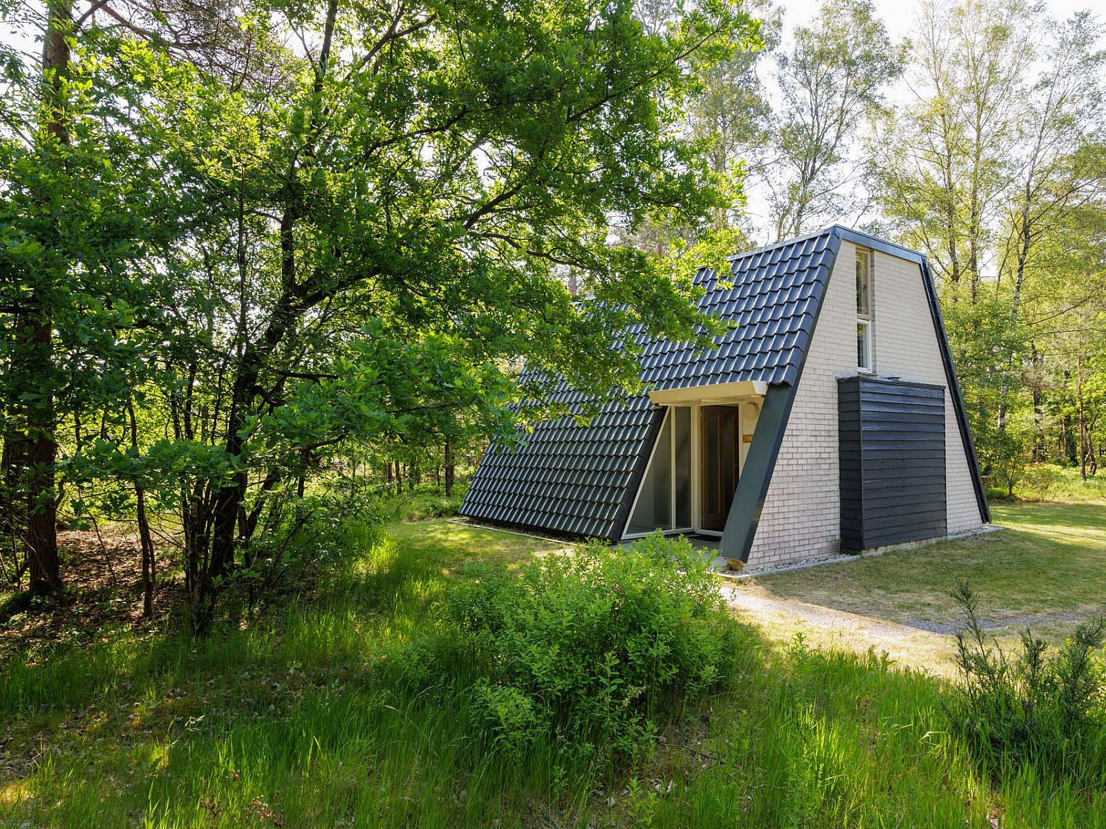 Vrijstaande woning in Hoenderloo op de Veluwe, omgeven door groene natuur in Gelderland, ideaal vakantiehuis voor rust en ontspanning.