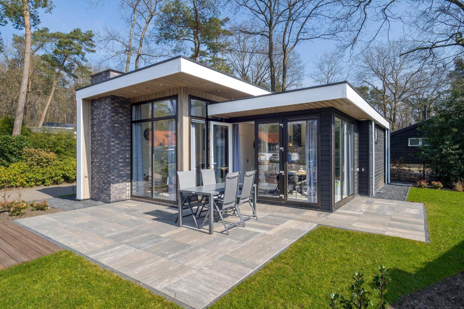 Spacious terrace at Vakantiewoning Hertenhoeve comfort in Hoenderloo, Veluwe. Ideal for outdoor dining and enjoying the surroundings.