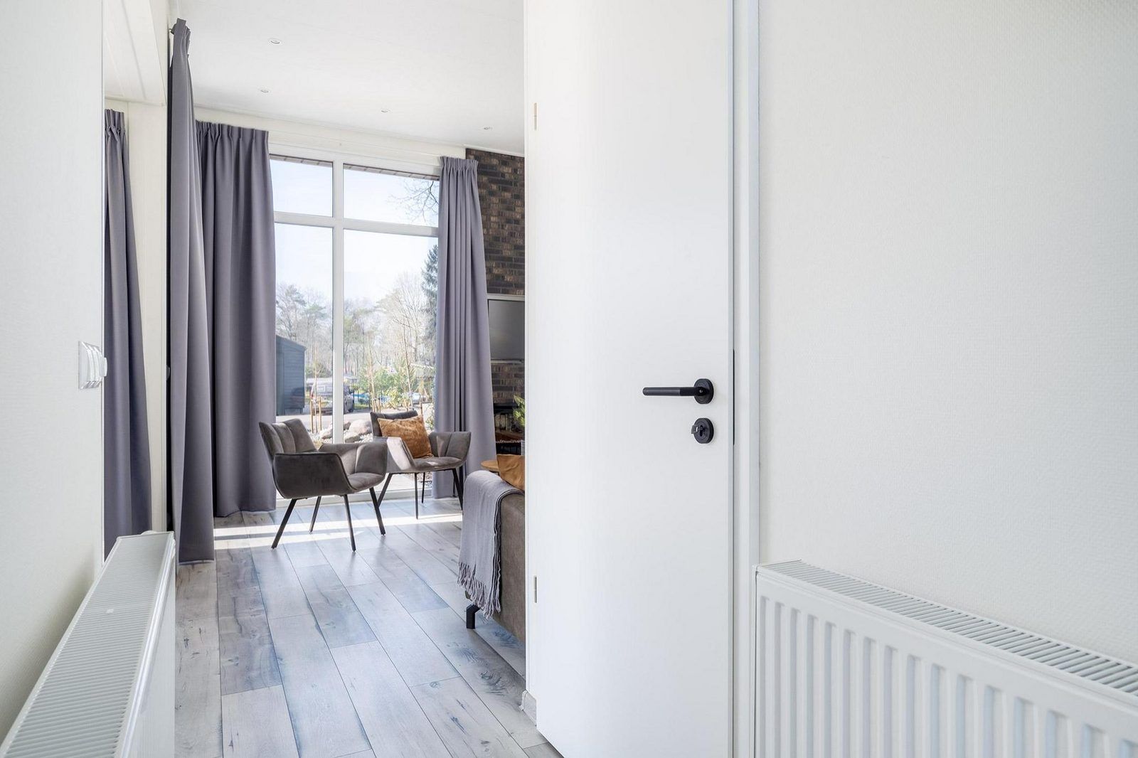 View through to the living room in Holiday home Hertenhoeve comfort in Hoenderloo, Veluwe. Spacious and bright interior.