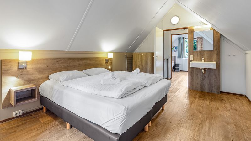 Gezellige slaapkamer met ensuite in Miggelenberg 8-persoons bungalow 8C, Hoenderloo, Veluwe.