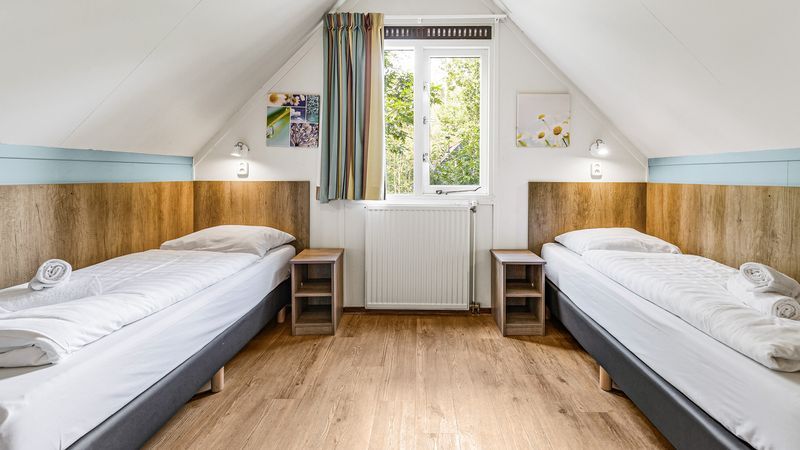 Slaapkamer met twee eenpersoonsbedden in Miggelenberg 8-persoons bungalow 8C, Hoenderloo, Veluwe.