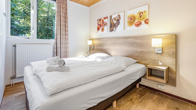Lichte slaapkamer met tweepersoonsbed in Miggelenberg 8-persoons bungalow 8C, Hoenderloo, Veluwe.