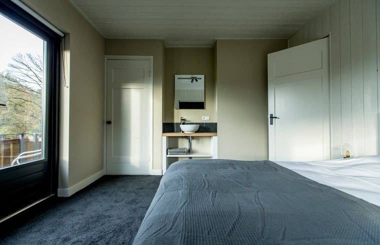 Lichte slaapkamer in Huisje in Hoenderloo, Veluwe, met prachtig uitzicht op de natuur.