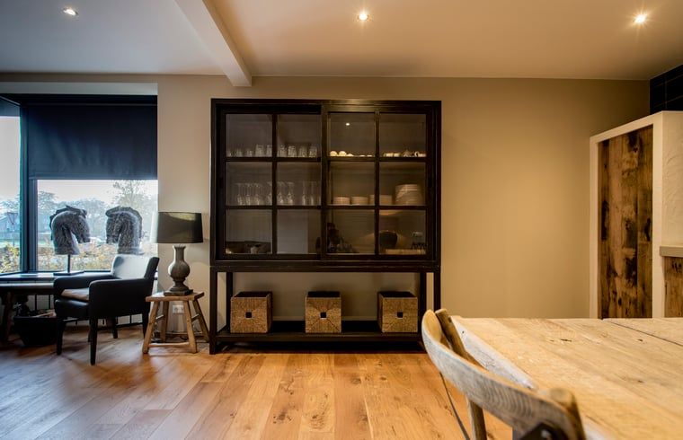 Gezellige zithoek in Huisje in Hoenderloo, Veluwe, met uitzicht op de tuin.