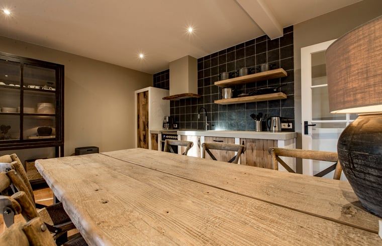 Rustieke eetkamer in Huisje in Hoenderloo, Veluwe, met houten tafel en stoelen.