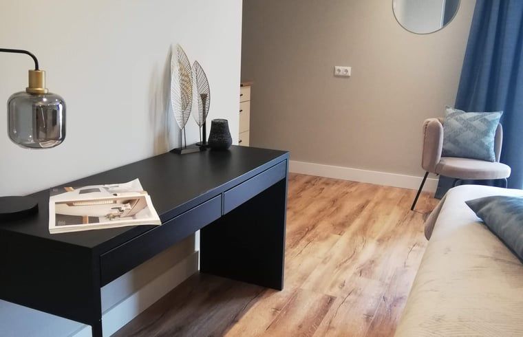 Stilvolles Interieur des Ferienhauses in Hoenderloo, Veluwe, mit Holzboden und moderner Einrichtung.