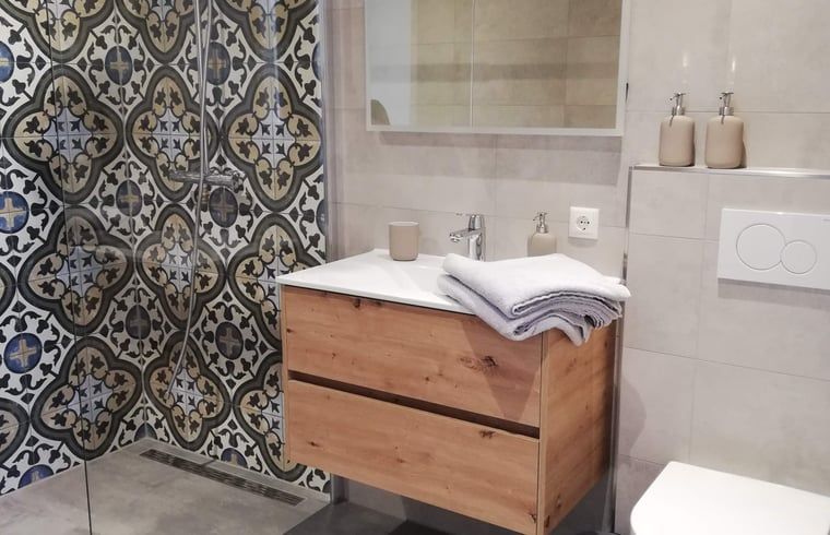 Luxurioeses Badezimmer im Ferienhaus in Hoenderloo, Veluwe, mit farbenfrohen Fliesen und modernen Annehmlichkeiten.