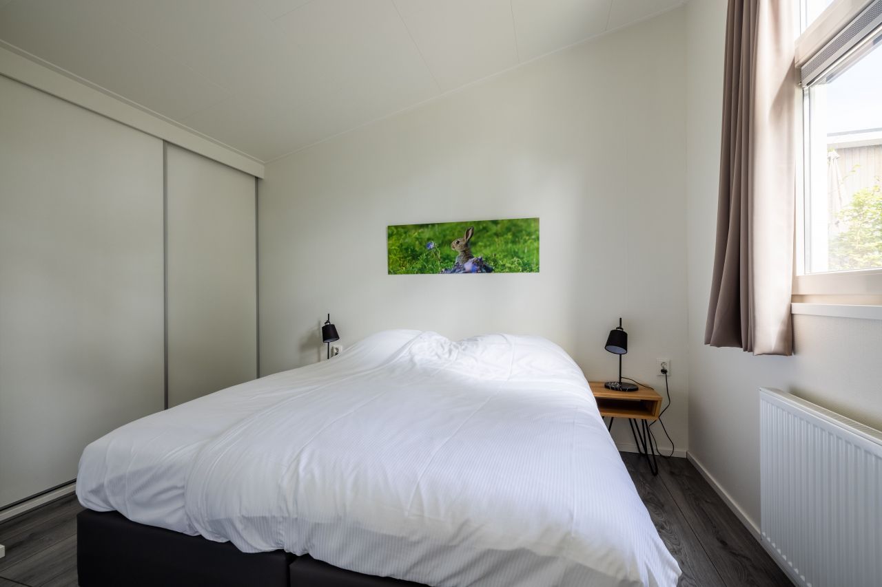 Master bedroom in the vacation home in Hoenderloo, Veluwe, with comfortable bed and serene atmosphere.
