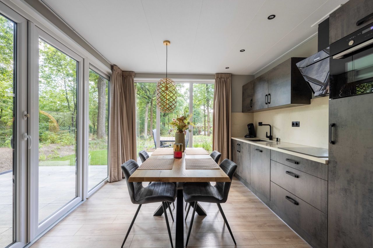 Gerumiges Esszimmer in freistehendem Haus in Hoenderloo, Veluwe, Gelderland. Ferienhaus mit Blick auf den Garten.