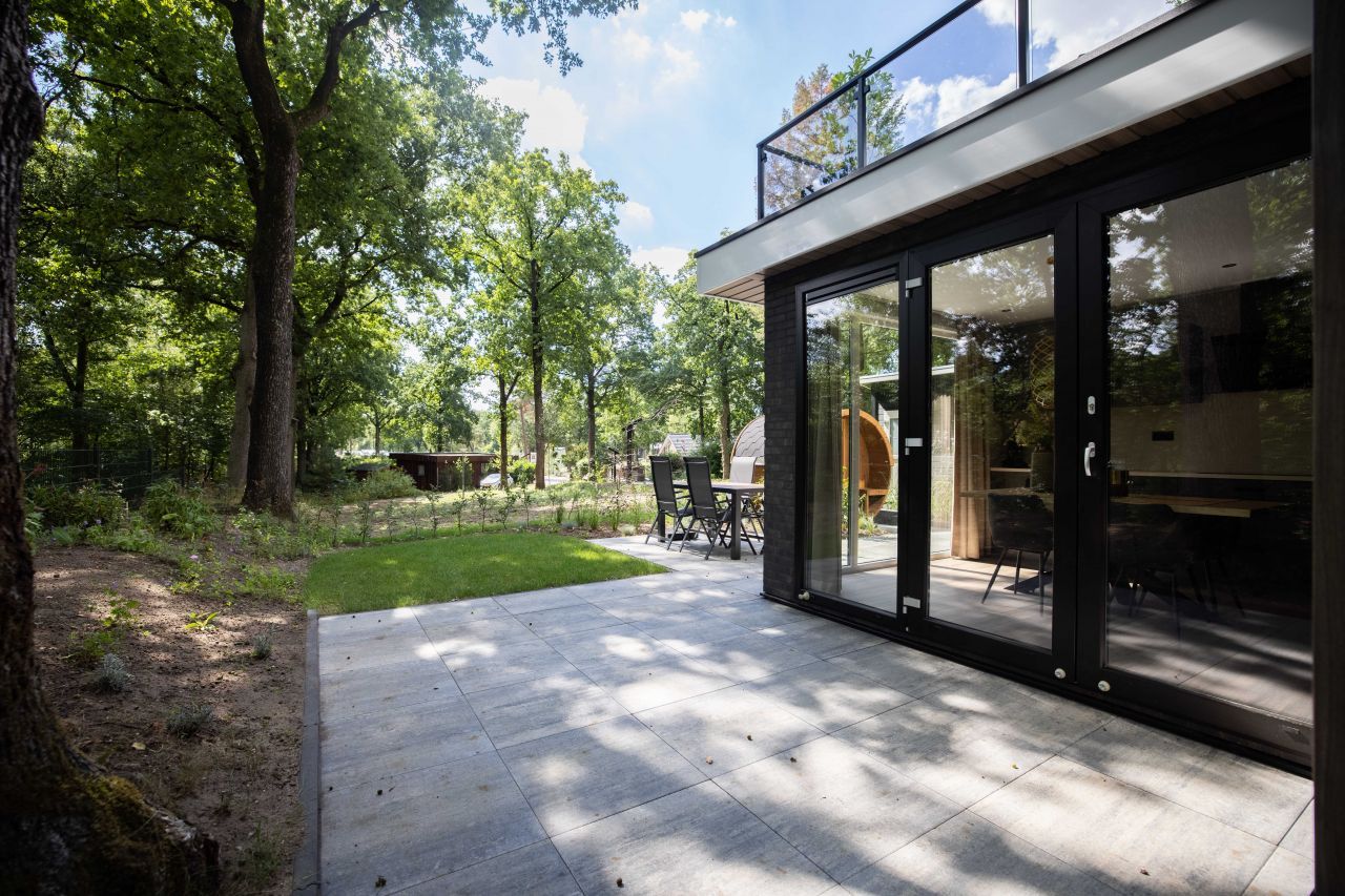 Terrasse und Garten eines freistehenden Hauses in Hoenderloo, Veluwe, Gelderland. Ferienhaus umgeben von Natur.