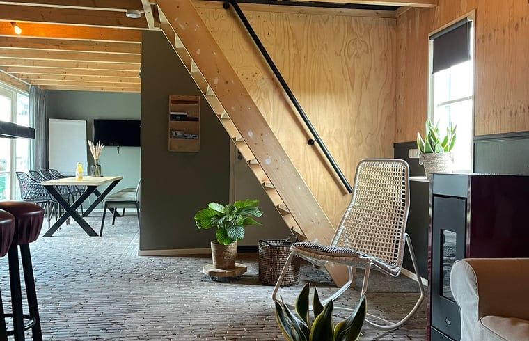 Cozy interior of Holiday Home in 't Harde, Veluwe, with wooden interior and sitting area.