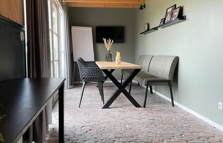 Dining room in Holiday Home in 't Harde, Veluwe, with modern furnishings and lots of natural light.