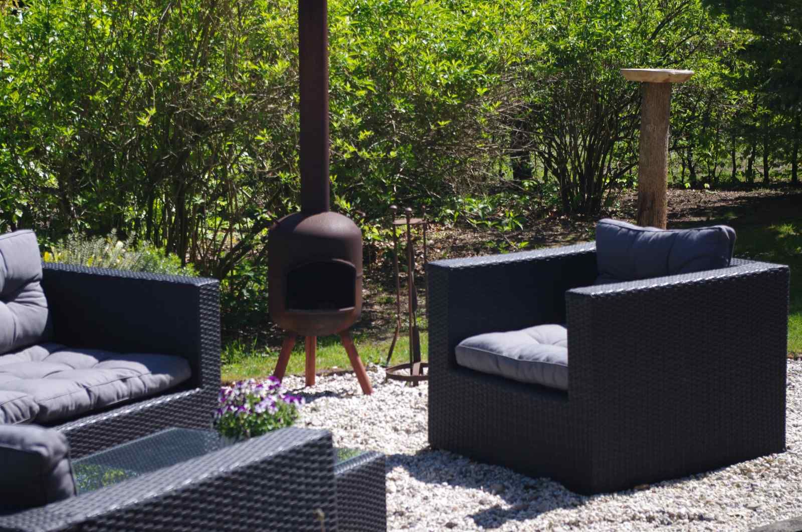 Terrace with comfortable chairs and outdoor fireplace at vacation home DG1276, Putten.