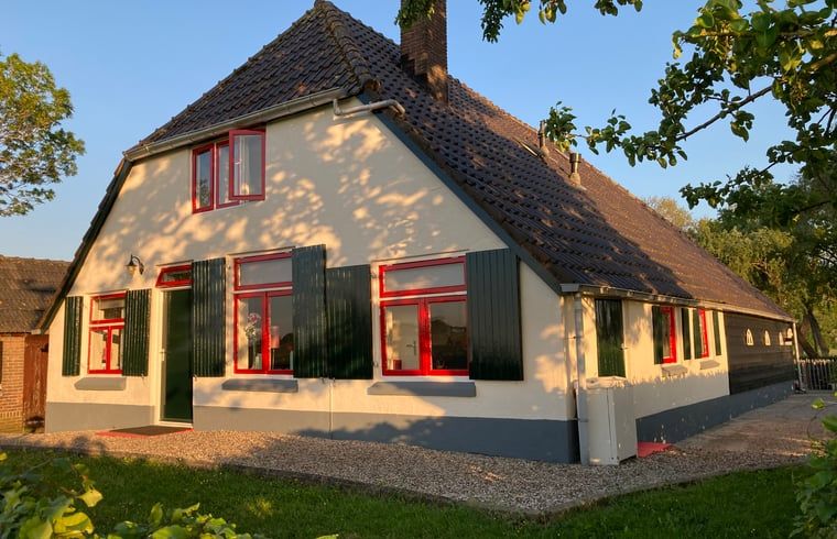 Cottage in Wezep Oldebroek, Veluwe, Gelderland in the evening sun with shady trees.